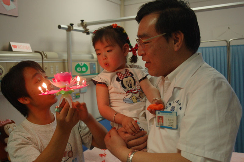 江苏省人民医院骨科主任范卫民抱着小馨懿，吹小莲灯（周宁人摄）.jpg